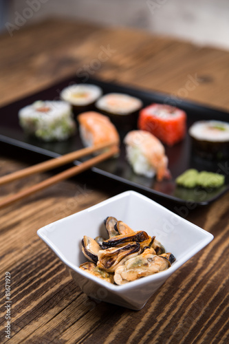 Sushi pieces collection with bamboo chopsticks, isolated on wooden table