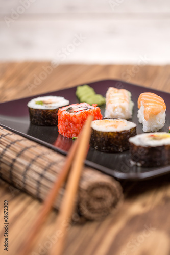 fresh Japanese tasty sushi roll set with chopsticks on wooden ta