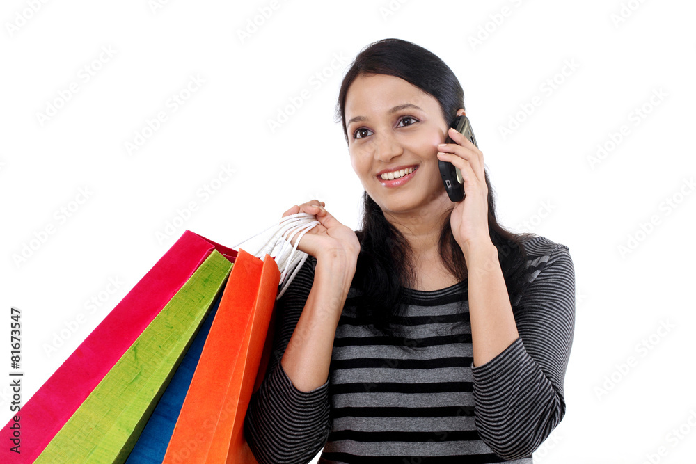 Young woman with shopping bags and talking on mobile phone Young woman with shopping bags and talking on mobile phone