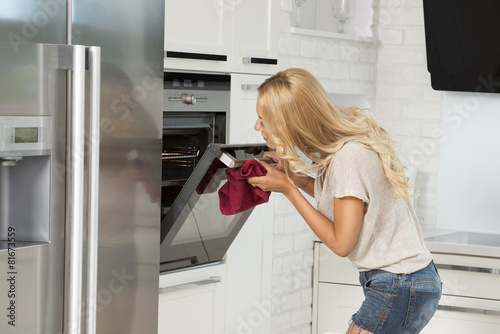 commercial girl looking food in oven