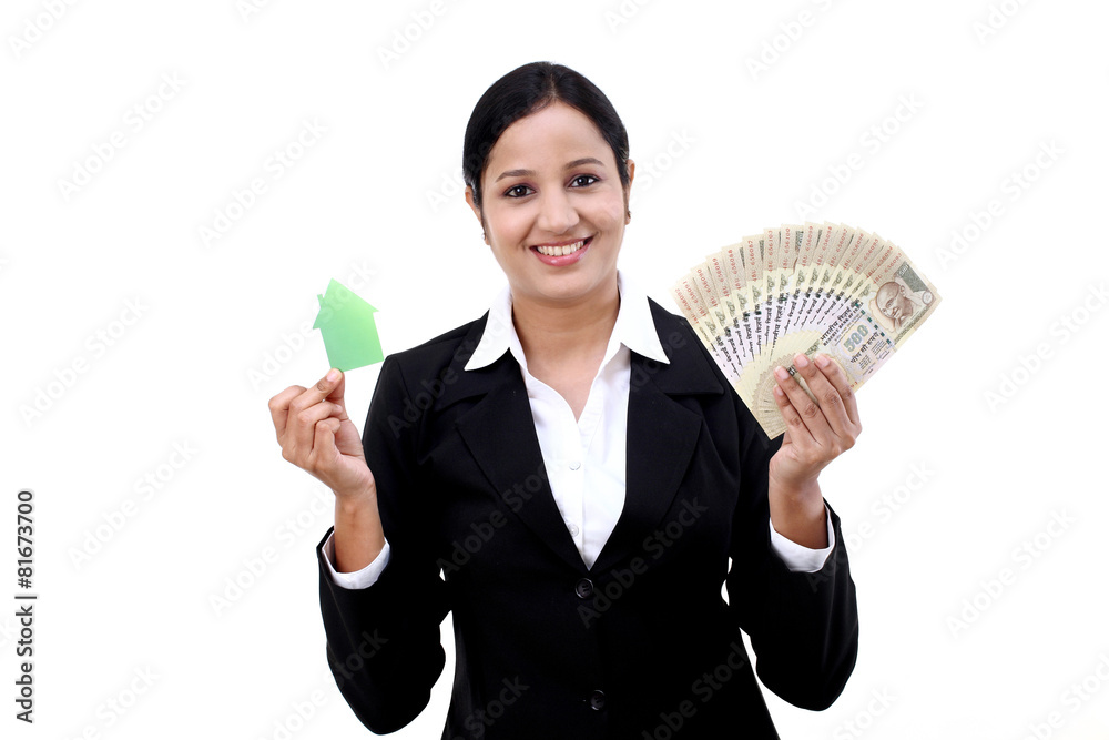 Young business woman with house model and Indian rupee notes in