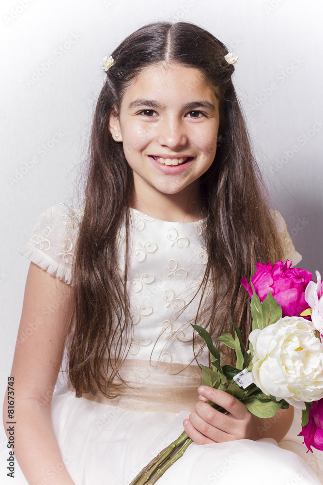 Smiling girl with communion dress holding bouquet of peonies. Smiling girl with communion dress holding bouquet of peonies.