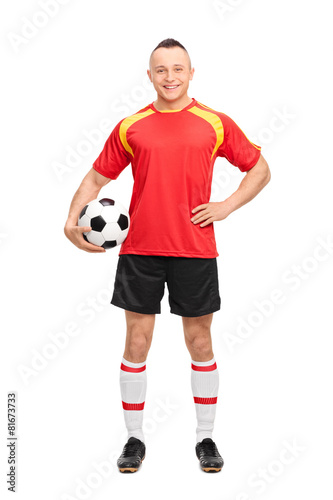 Full length portrait of a young soccer player holding a ball