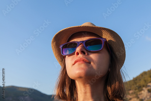 Young woman in a hat and sunglasses