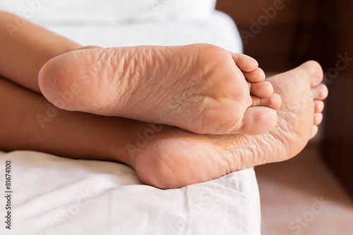 Two feet in a bed against a white background