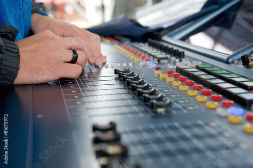 Man operating studio audio mixer
