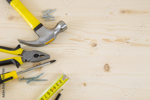 Set of carpenter tools and supplies on wooden surface including photo