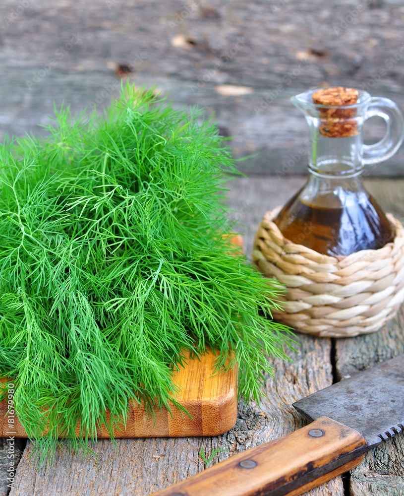 Fototapeta premium Bunch of fresh dill with olive oil on a wooden table