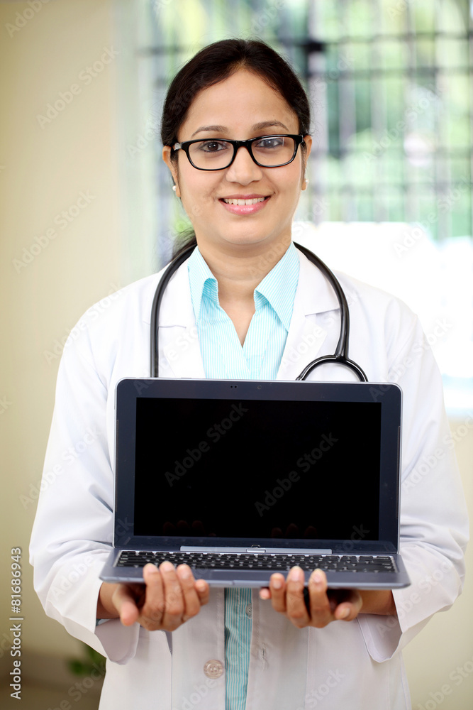 Female doctor pointing in laptops blank screen Female doctor pointing in laptops blank screen