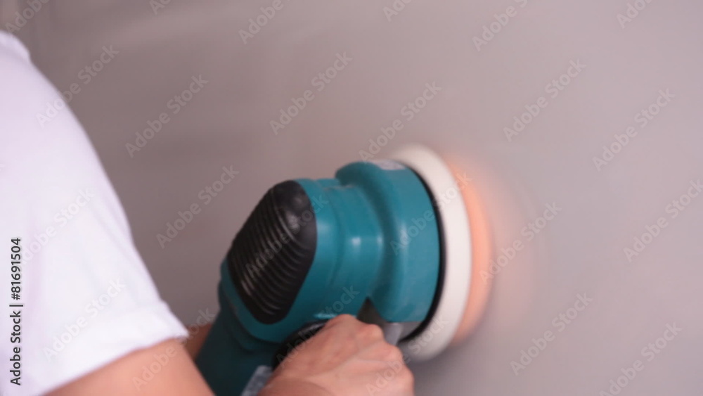 Worker Polishing the car with power buffer machine . Worker Polishing the car with power buffer machine .