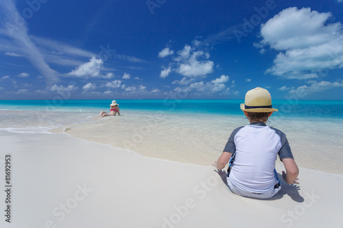 Family relaxing on at tropical beach in turquoise waters © PhotoSerg