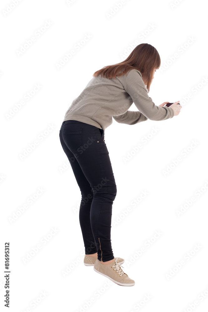 back view of standing young beautiful  woman and using a mobile
