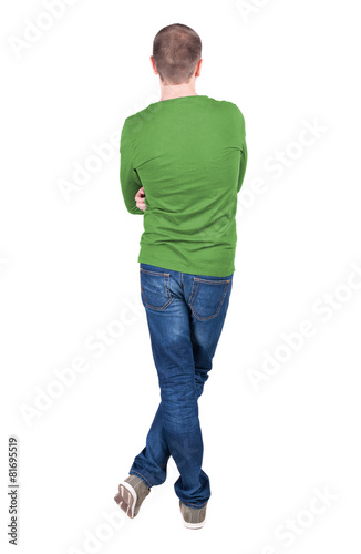 Back view of young man in t-shirt and jeans looking.