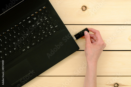 Canvas Print Hand inserting usb memory stick to laptop computer