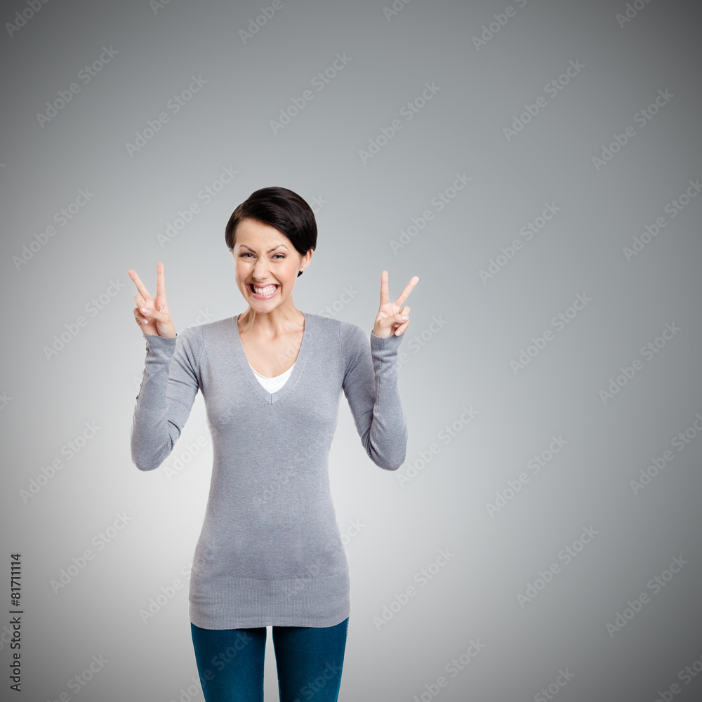 Smiley woman shows victory sign with two hands, isolated on white Smiley woman shows victory sign with two hands, isolated on white