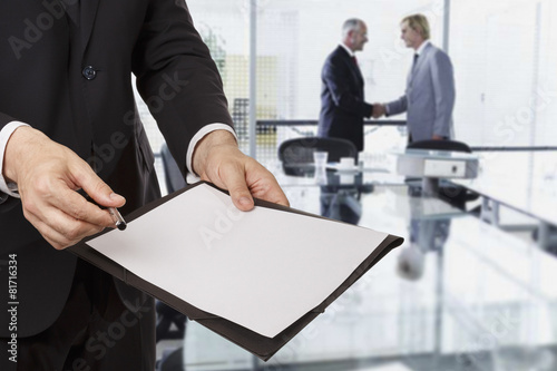 Businessman giving a document to you