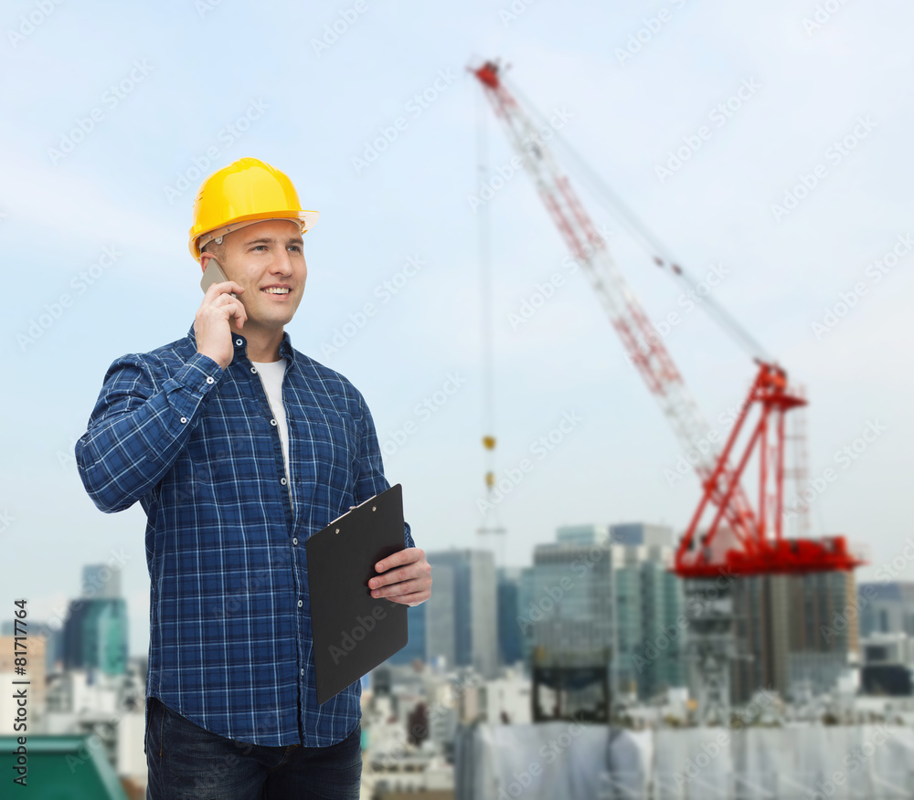 smiling male builder in helmet with clipboard smiling male builder in helmet with clipboard