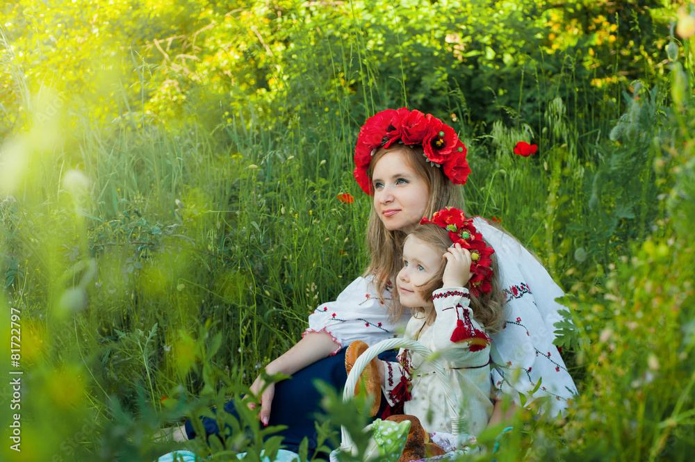Mom and daughter in traditional Ukrainian costume in the forest Mom and daughter in traditional Ukrainian costume in the forest