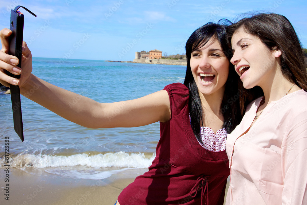 Two happy young women taking selfie smiling on the beach Two happy young women taking selfie smiling on the beach