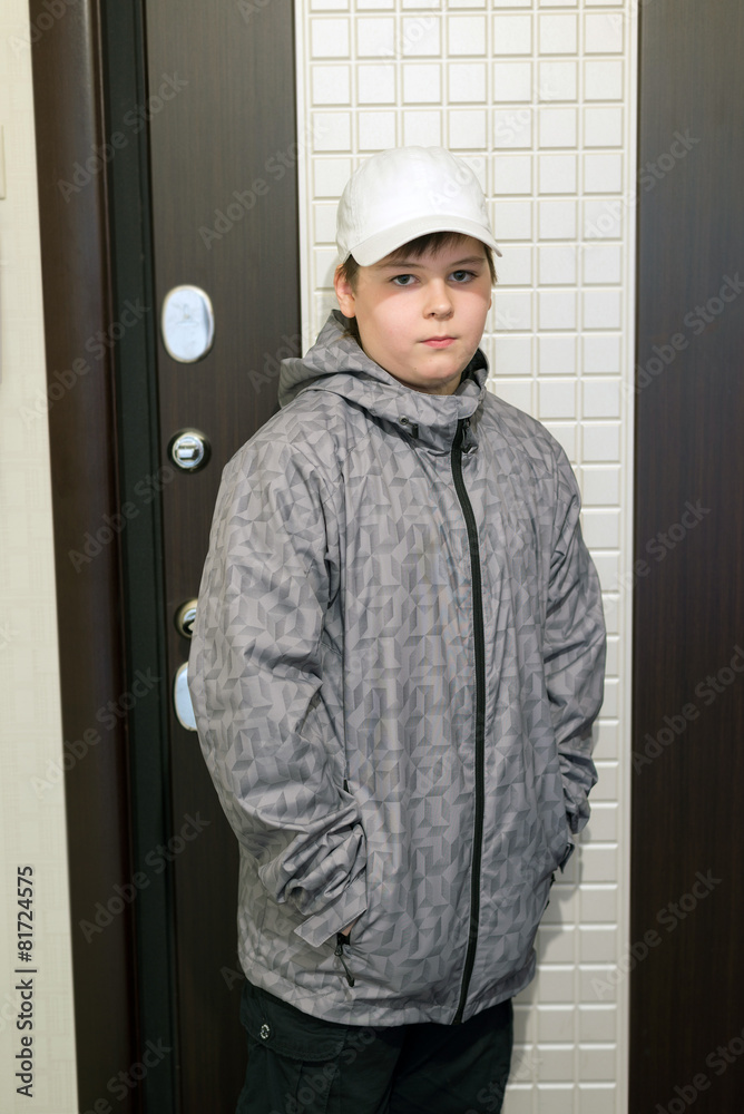 boy standing at  front door of the house