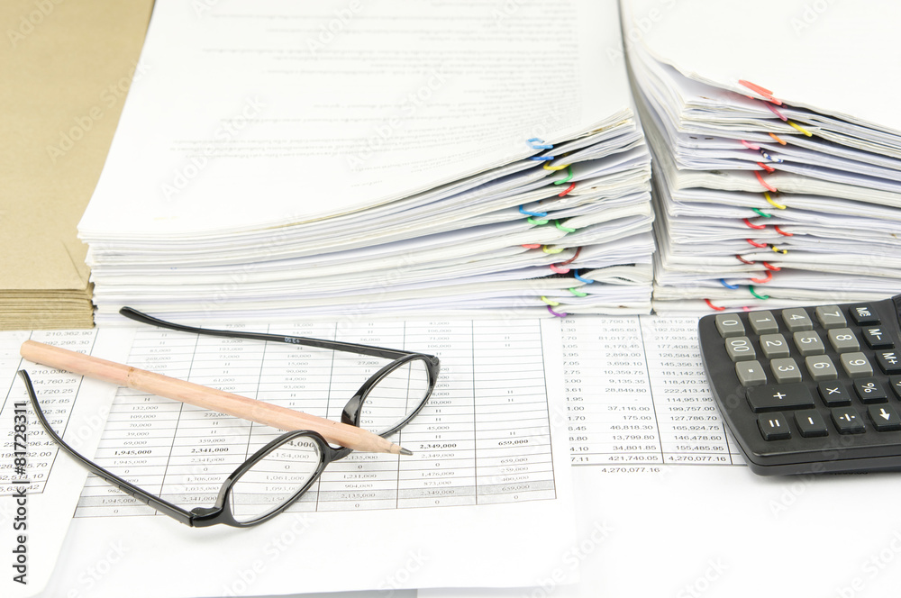 Brown pencil on spectacles and calculator Brown pencil on spectacles and calculator