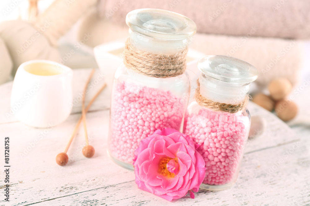 Glass bottles with color spa sea salt on wooden table, closeup Glass bottles with color spa sea salt on wooden table, closeup