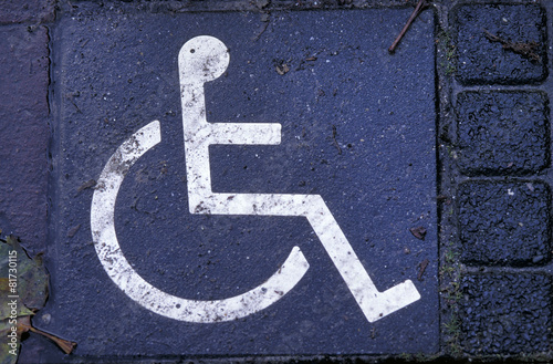 handicap sign on tile of street