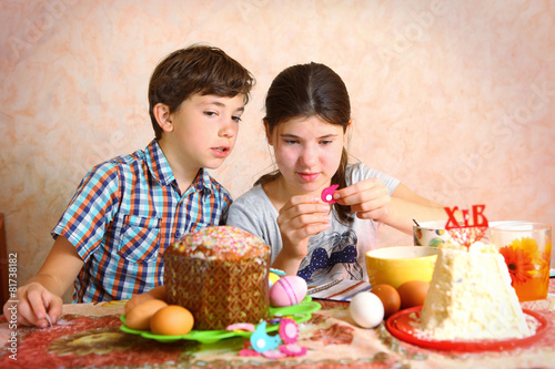 siblings brother and sister decorate egg and easter cake for eas photo