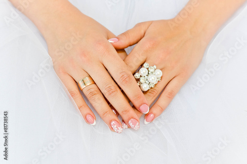 Gemstone ring with pearls on the fingers of the bride
