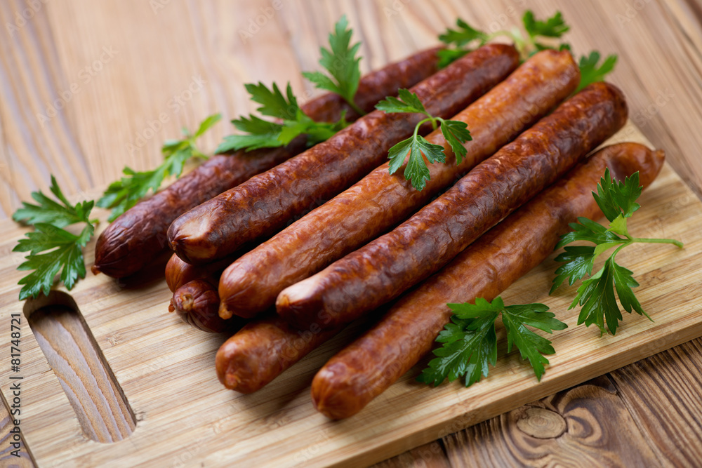 Sausages with fresh parsley on a wooden chopping board, close-up Sausages with fresh parsley on a wooden chopping board, close-up