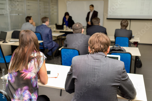 The audience listens to the acting in a classroom