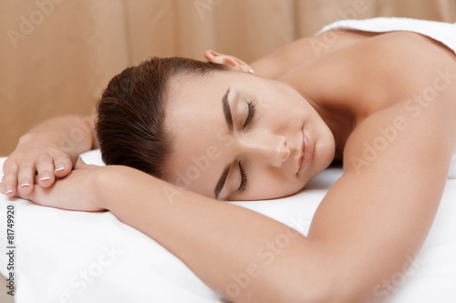 Woman enjoys massage in spa salon