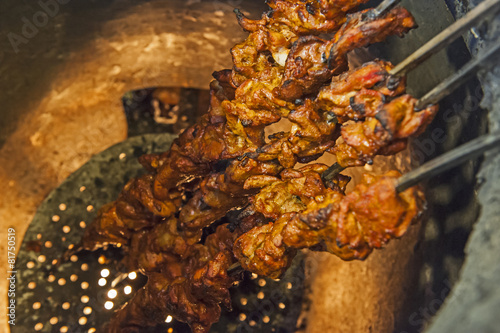 Chicken kebabs cooking in a tandoori oven