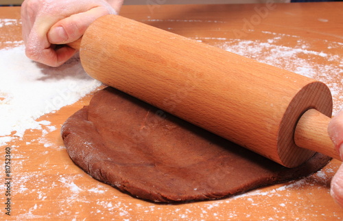 Hand with rolling pin kneading dough for cookies