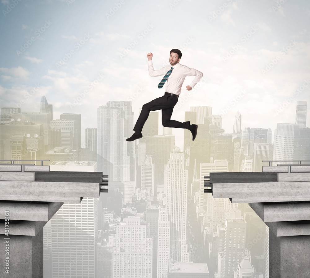 Energetic business man jumping over a bridge with gap