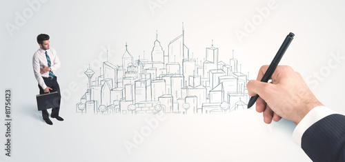 Businessman looking at hand drawn city on wall