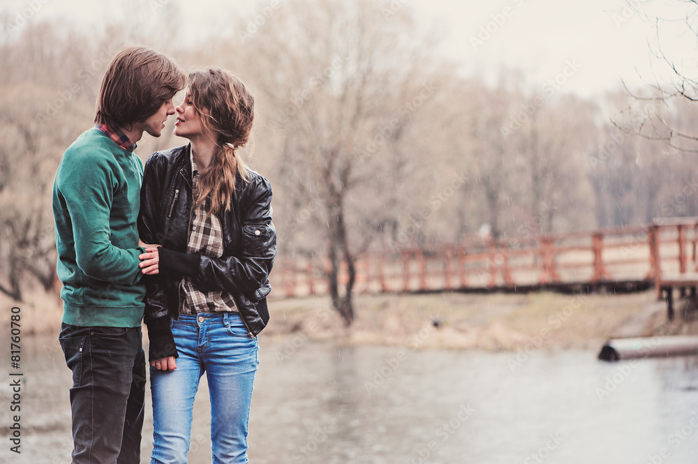 Fototapeta premium young loving couple on the walk in early spring riverside