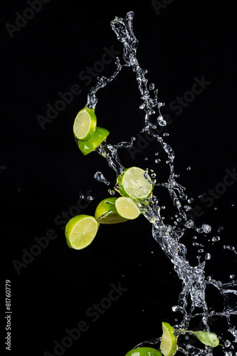 Limes with water splashes on black background