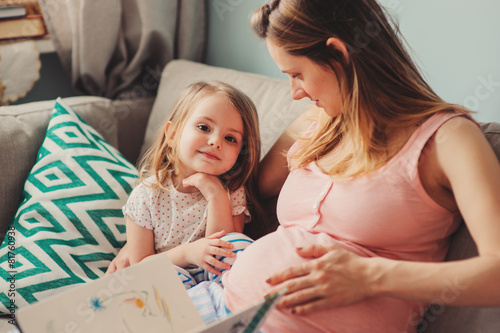 Wallpaper Mural pregnant woman reading book to happy child daughter Torontodigital.ca