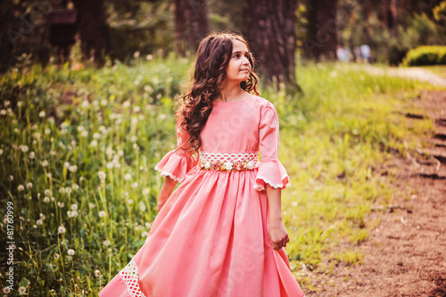happy child girl in fairytale princess dress dancing in forest