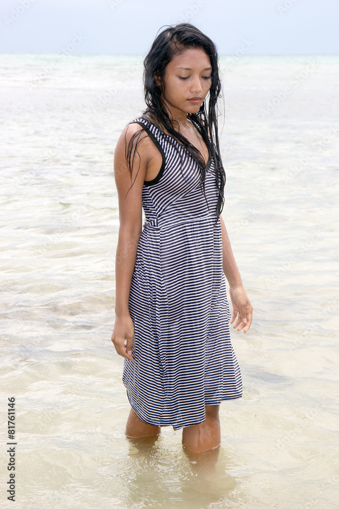 Young woman in wet dress walkin in the sea Young woman in wet dress walkin in the sea