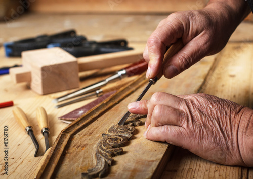 Foto Close up of senior carpenter hands restoring old furniture with chisel