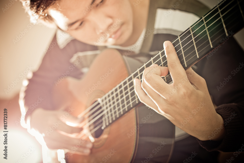 Fototapeta premium Practicing in playing guitar. Handsome young men playing guitar
