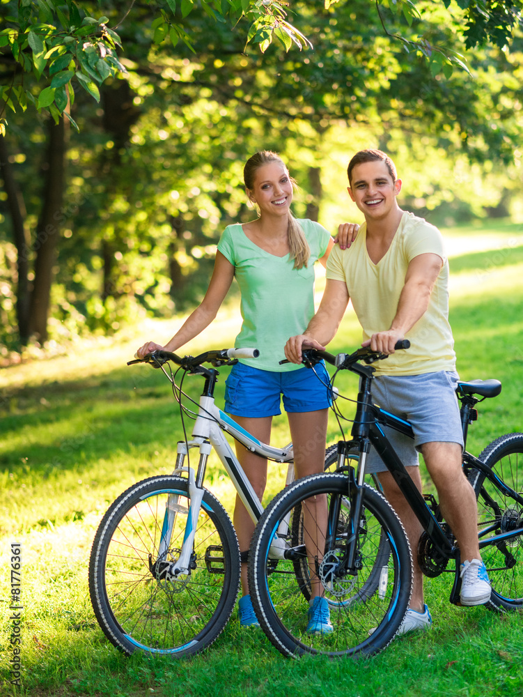 Smiling couple on bicycles outdoors