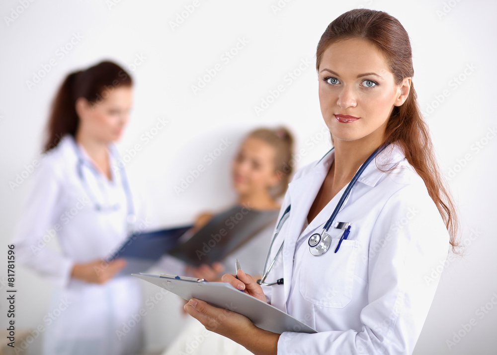 Smiling female doctor with a folder in uniform standing at Smiling female doctor with a folder in uniform standing at