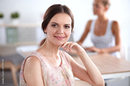 Free Download Attractive businesswoman sitting  on desk in the office - GFXLoad