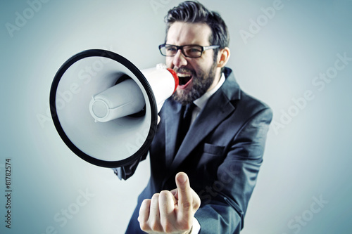 Agressive businessman yelling over the megaphone photo