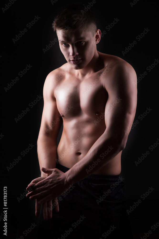 Handsome athletic muscular man over black background. Handsome athletic muscular man over black background.