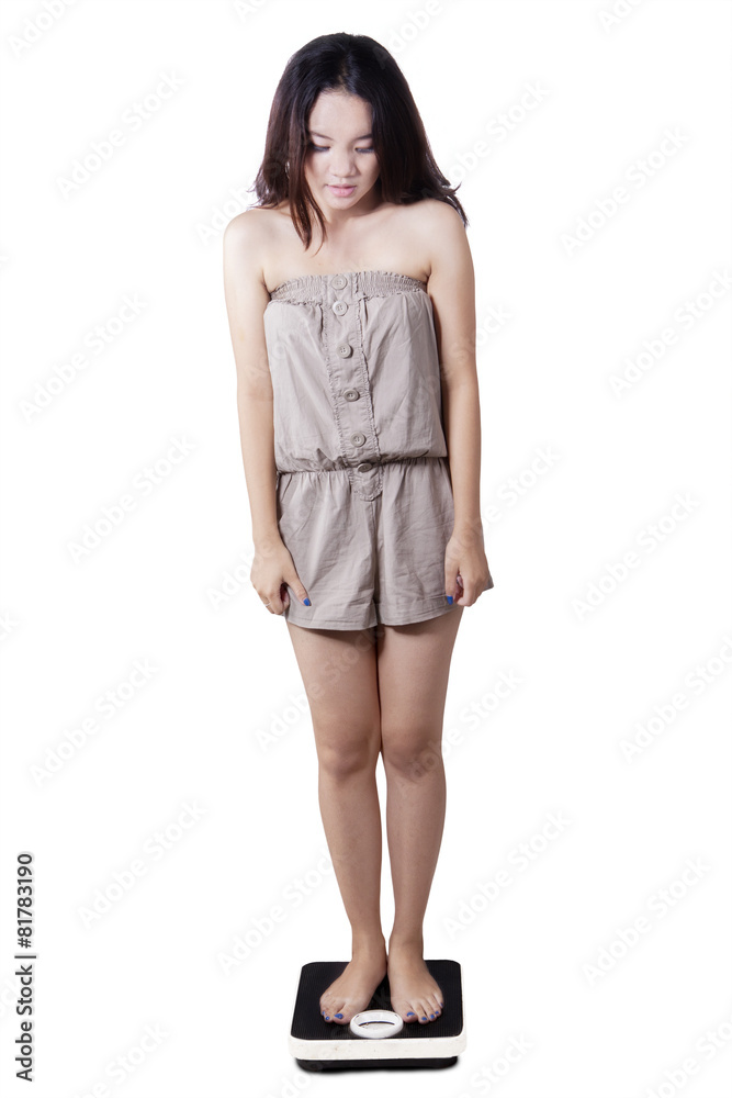 Fototapeta premium Teen girl standing on weight scales