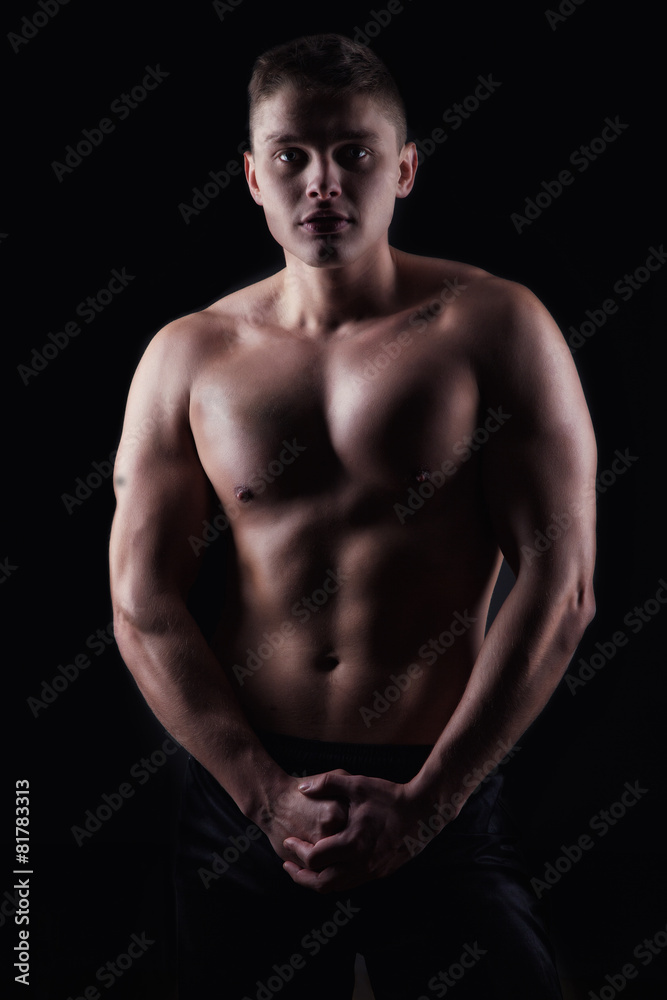 strong athletic man on black background